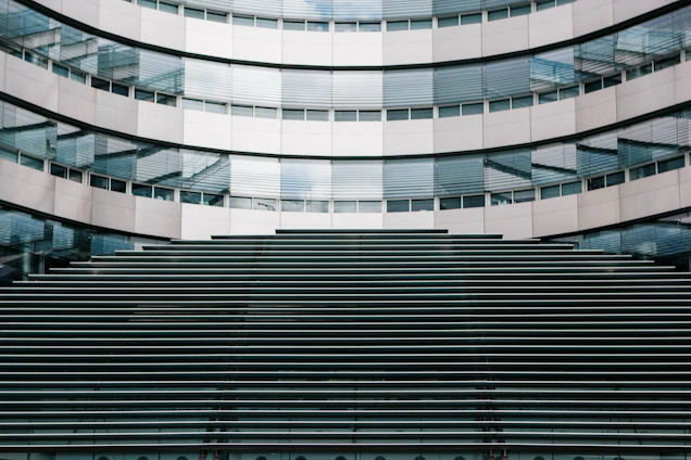 A sleek modern building facade featuring aluminum doors and glass curtain walls reflecting the Qatari skyline.