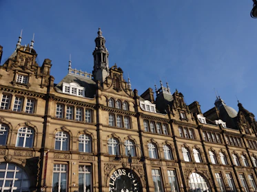 A beautifully restored historic building with fresh paint and updated roofing under a clear sky.