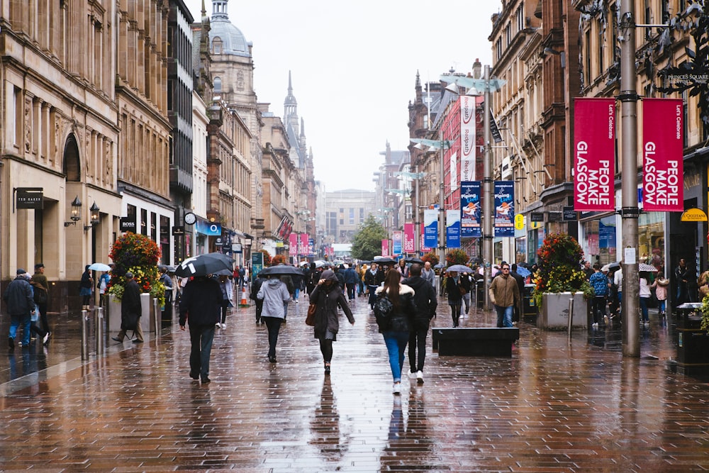 Eine Gruppe von Menschen, die mit Regenschirmen eine Straße entlang gehen