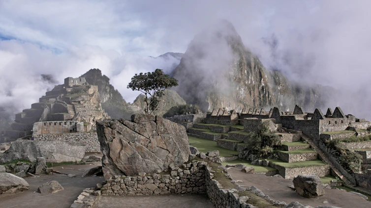 Elegant photo of Machu Picchu at sunrise, highlighting ancient stone terraces and misty mountains.