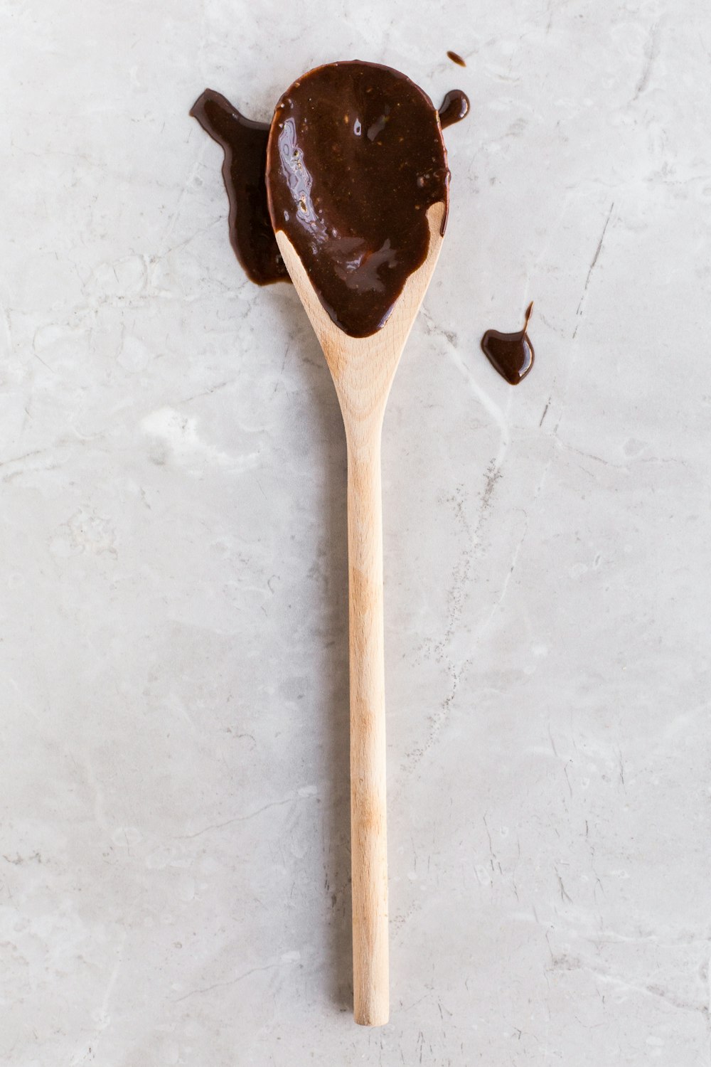 uma colher de pau com um chocolate espalhado sobre ele