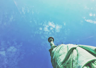 A majestic view of the Statue of Liberty standing tall against a clear blue sky.