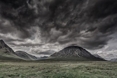 green grass field with mountains during nighttime stormy zoom background