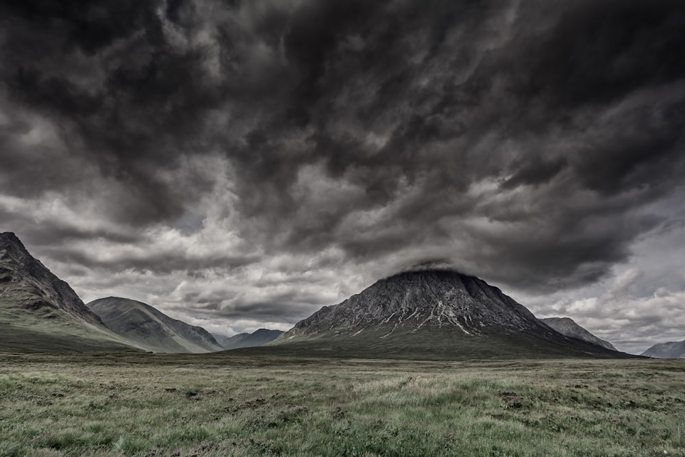 Campo de hierba verde con montañas durante la noche