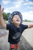Cute toddler wearing a colorful Kidrise t-shirt playing outside on a sunny day