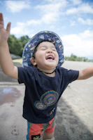 A joyful child wearing a vibrant outfit, playing outdoors on a sunny day.
