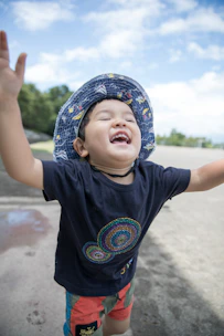 A joyful child wearing colorful casual clothes playing outdoors in a sunny park.