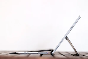 A sleek flexora stand holding a tablet at a perfect viewing angle on a wooden desk.