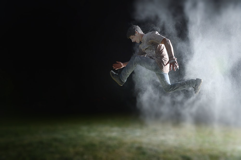 man in gray shirt jumping during night time