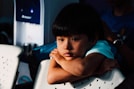 boy leaning on white chair