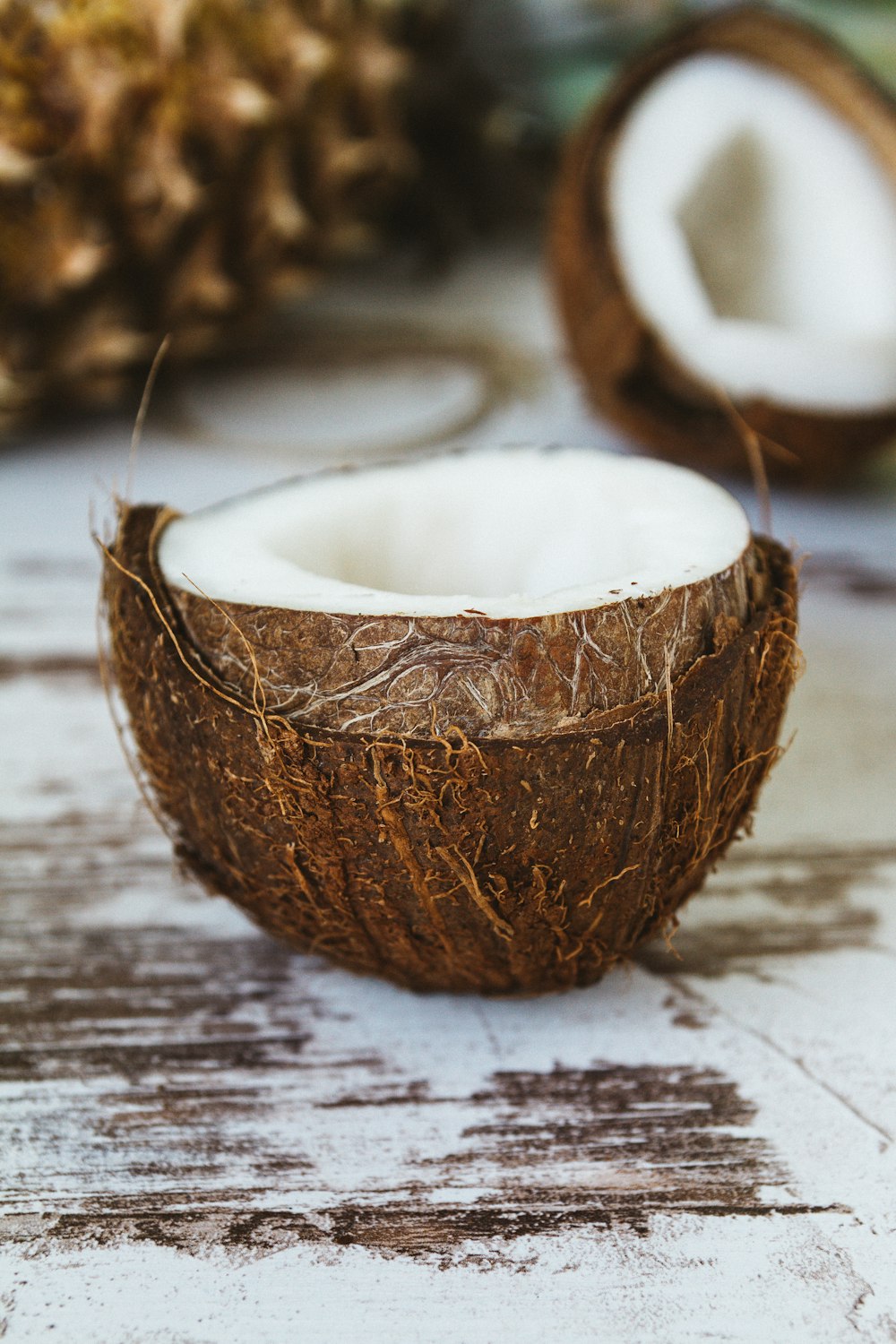 Eine halb gegessene Kokosnuss sitzt auf einem Holztisch