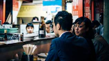 A vibrant photo of a bustling sushi bar with happy customers enjoying their meals.