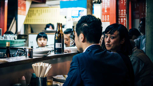 A vibrant photo of a bustling sushi bar with happy customers enjoying their meals.