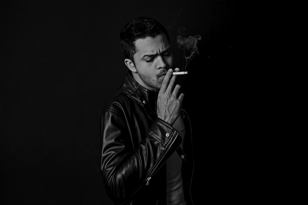 grayscale photo of man smoking cigarette