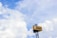 A large sign with the word 'emart' is mounted on a pole against a backdrop of a bright blue sky filled with fluffy white clouds.
