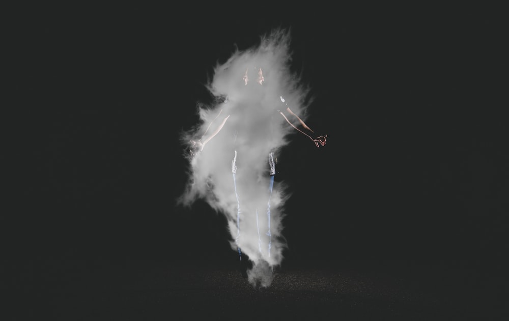 person standing near smoke with black background