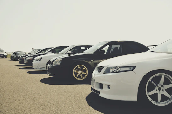A sleek lineup of various cars parked outdoors under clear skies, showcasing the current stock.