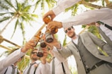 low angle of men holding beer bottles and having a toast