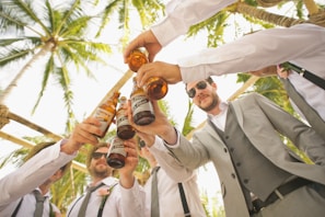 low angle of men holding beer bottles and having a toast