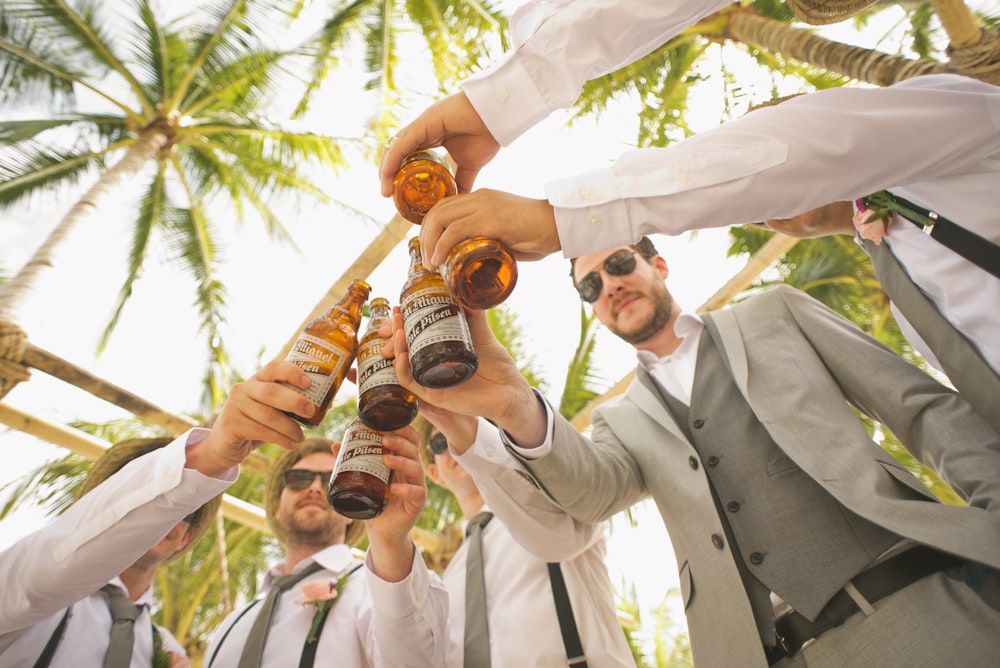 low angle of men holding beer bottles and having a toast