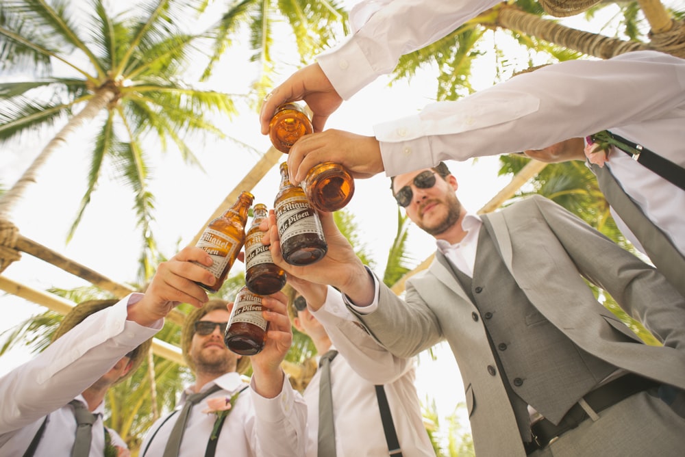 Contre-plongée d’hommes tenant des bouteilles de bière et portant un toast