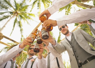 low angle of men holding beer bottles and having a toast