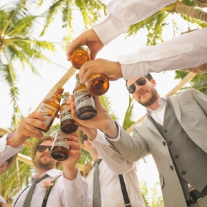 low angle of men holding beer bottles and having a toast