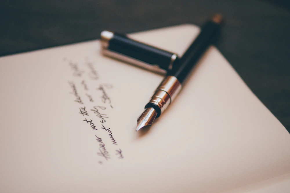 A fountain pen near cursive writing on white stationery