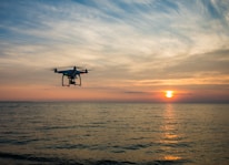 quadcopter flying over body of water