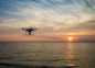 quadcopter flying over body of water