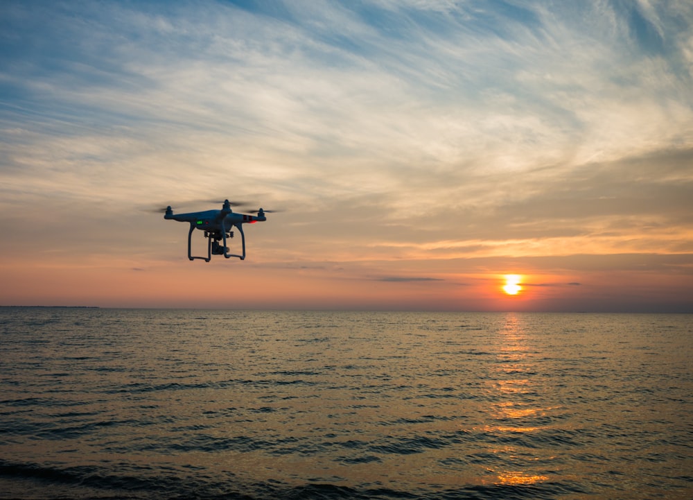 quadcopter flying over body of water