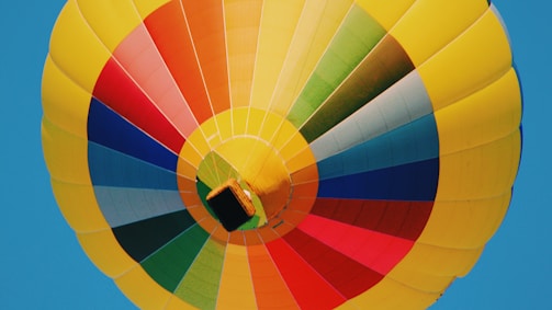 A vibrant drone photo capturing a colorful hot air balloon festival from above.