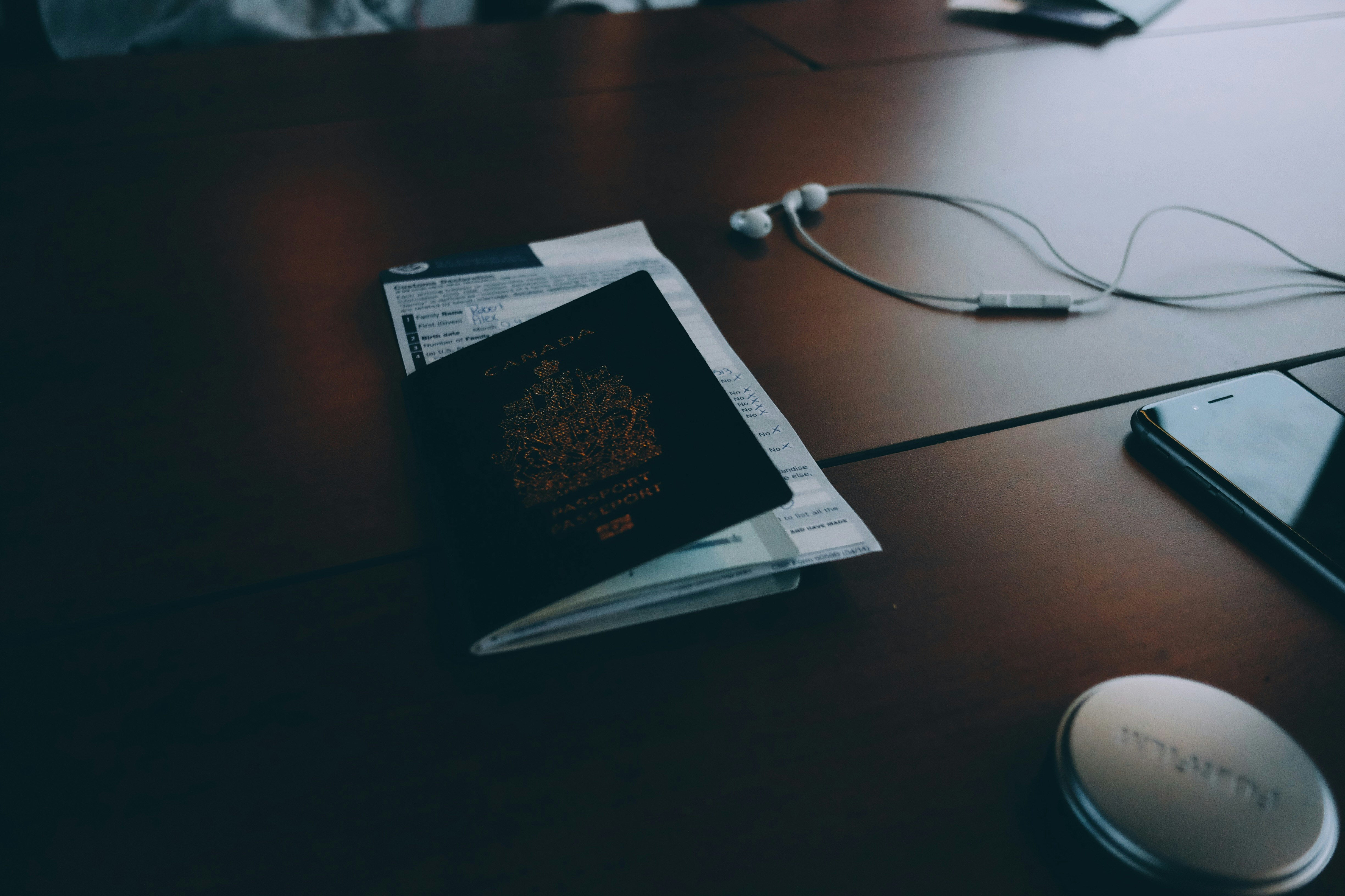 passport beside earphones on surface