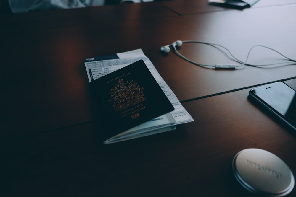 Passport and documents on desk near phone and headphones