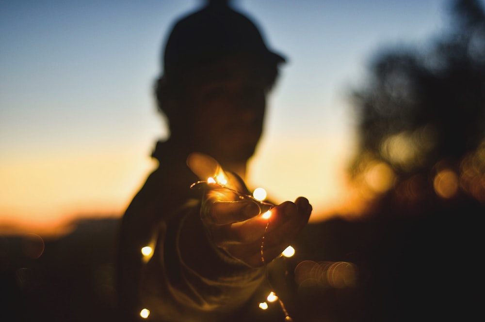 person holding string lights at nightitme