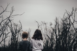 boy and girl surrounded by trees