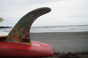 A detailed shot of a surfboard fin slicing through foamy white water
