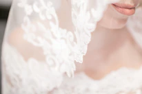 Close-up of a bride smiling with flawless makeup and elegant hairstyle in natural light.