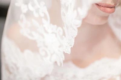 Close-up of a bride smiling with flawless makeup and elegant hairstyle in natural light.