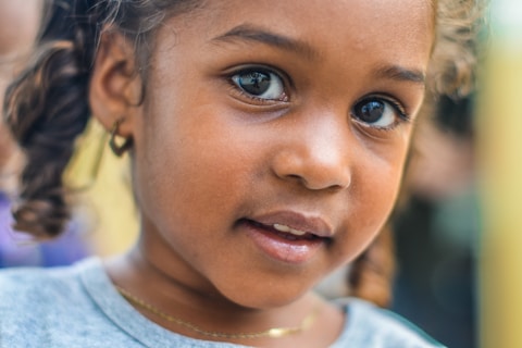 close-up photography of child wearing gray top