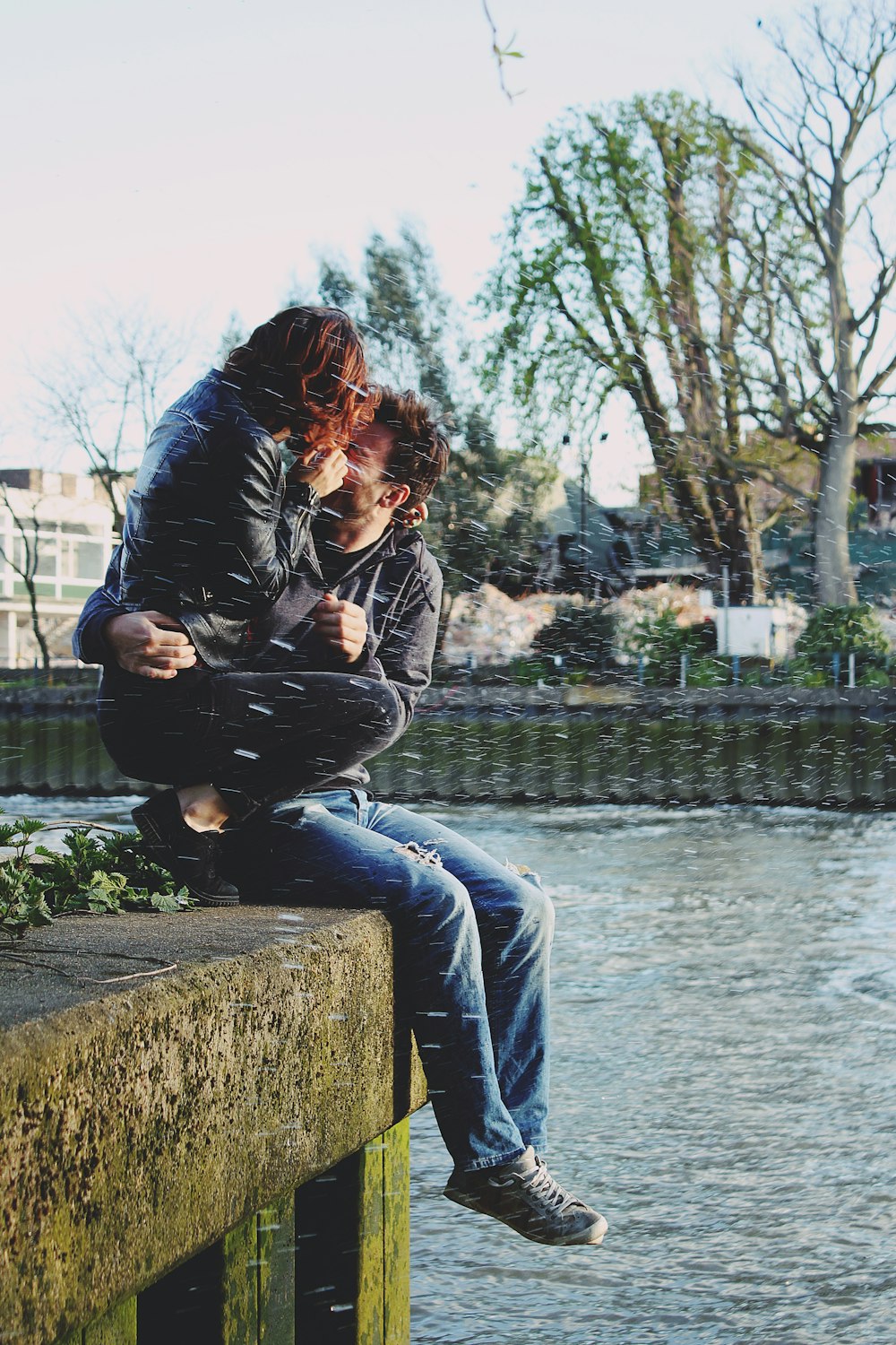 a couple of people sitting on top of a bridge