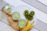 fruit juice cups beside yellow bananas on plate