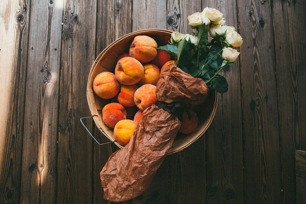 Schale mit Früchten und Strauß mit weißen Blumen