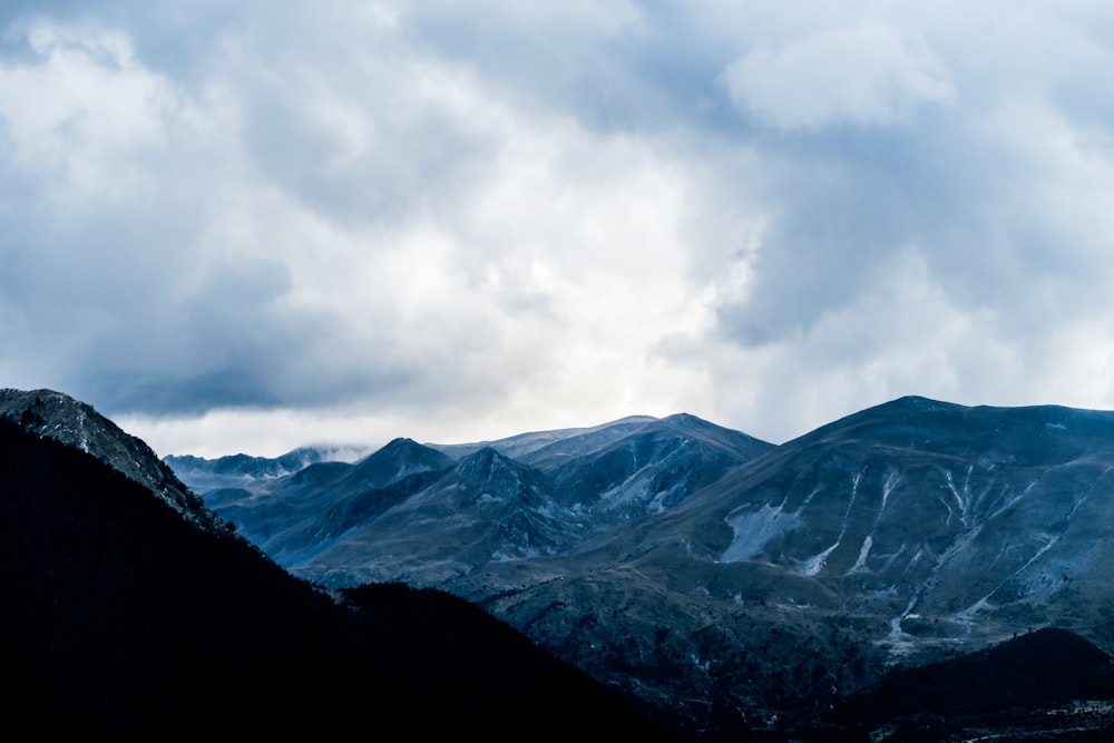 mountain range under cloudy sky during daytime