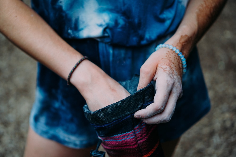 close-up photography of person holding black and pink pouch