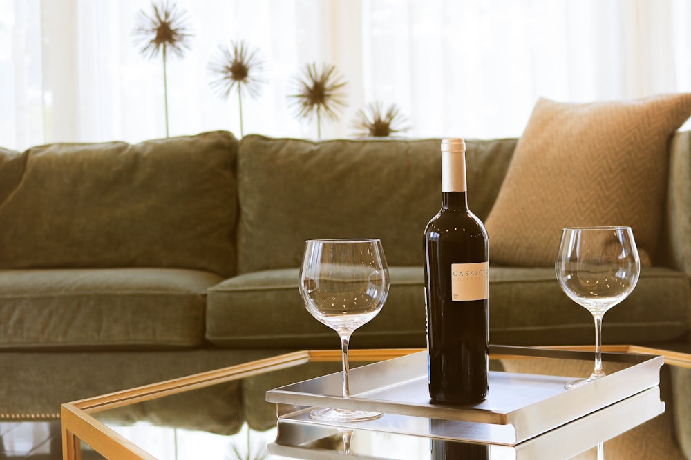 garrafa de vinho preto ao lado de duas taças de vinho