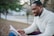man wearing white sweater while reading book