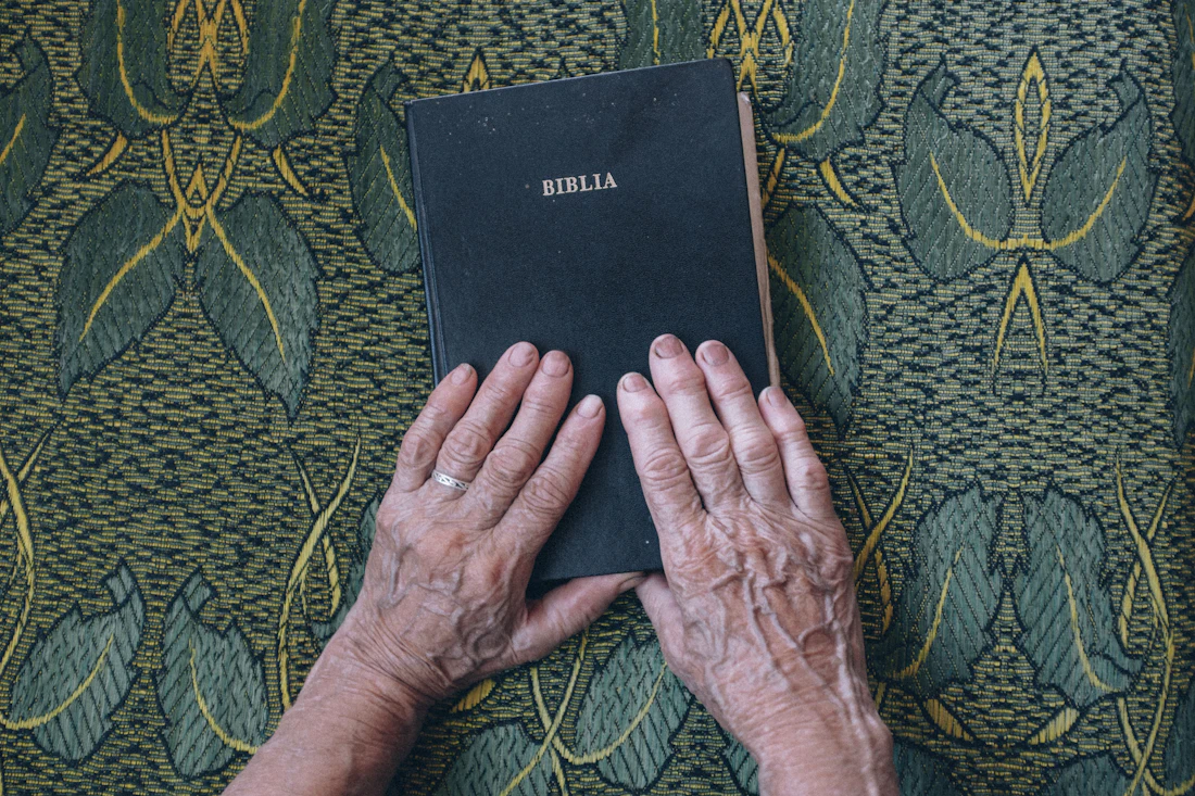 Hands resting on an open Bible in prayer