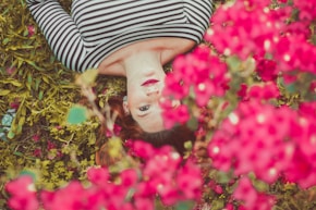woman in black and white striped top lying on grass