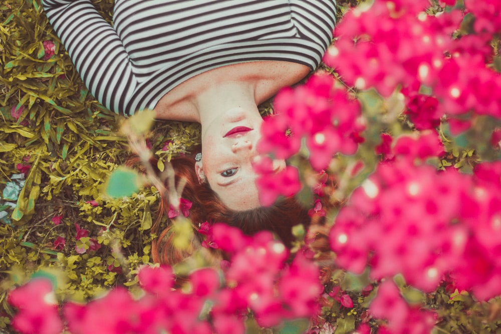 Femme en haut rayé noir et blanc couché sur l’herbe